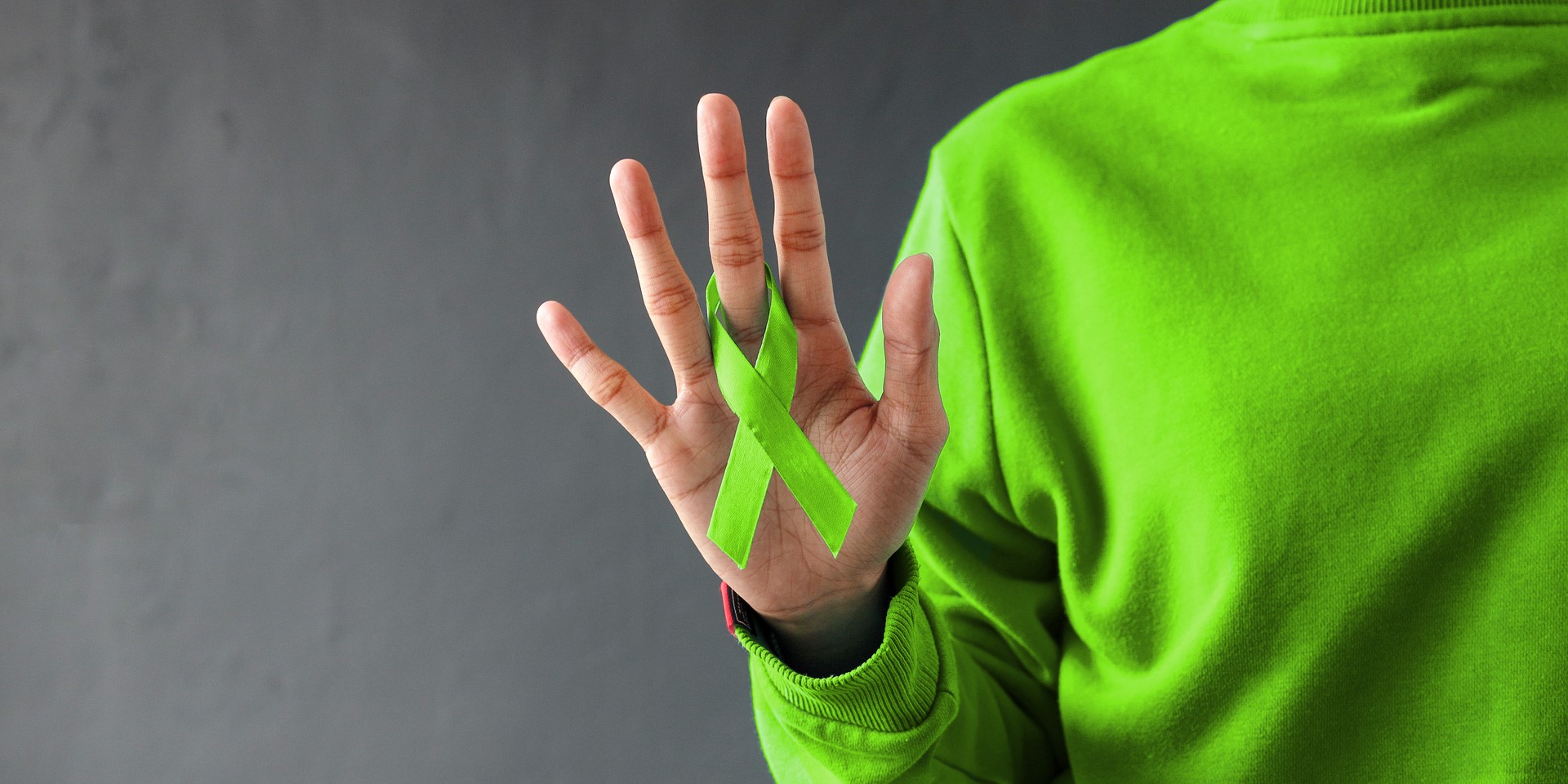 Titelbild Woche der Seelischen Gesundheit | Eine ausgestrecke Hand mit einer grünen Schleife als Symbol für Seelische Gesundheit